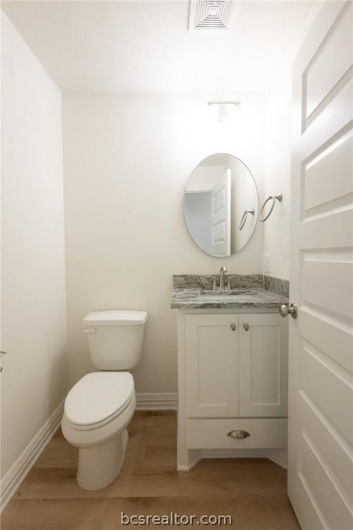 bathroom featuring vanity, toilet, and wood-type flooring