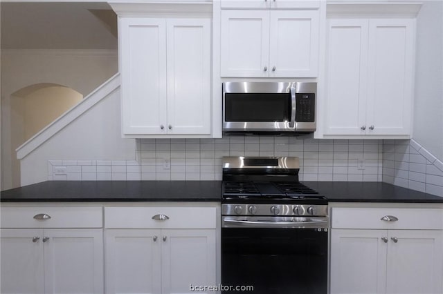 kitchen with tasteful backsplash, white cabinets, and appliances with stainless steel finishes