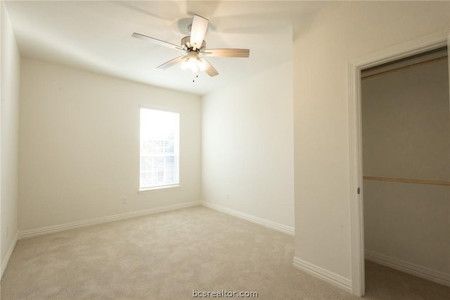 unfurnished bedroom featuring ceiling fan, a closet, and light carpet