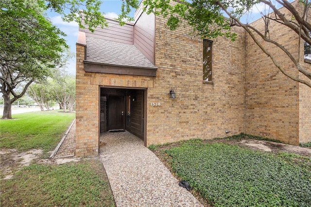 1538 Wolf Run, College Station, TX 77840 - entrance to property with a shingled roof, a yard, and brick siding