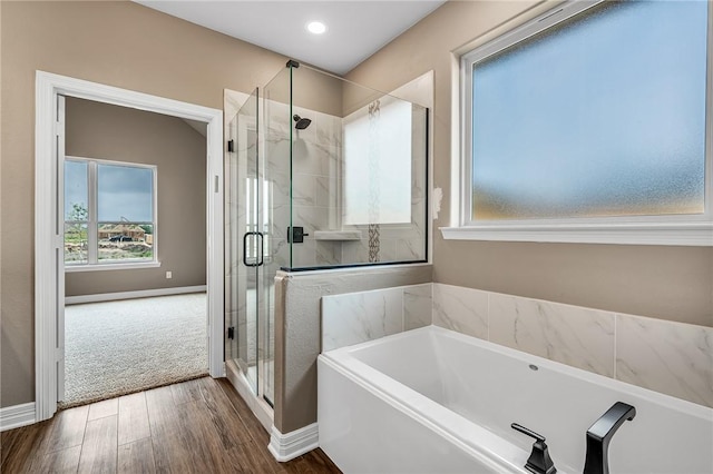 bathroom featuring shower with separate bathtub and hardwood / wood-style floors