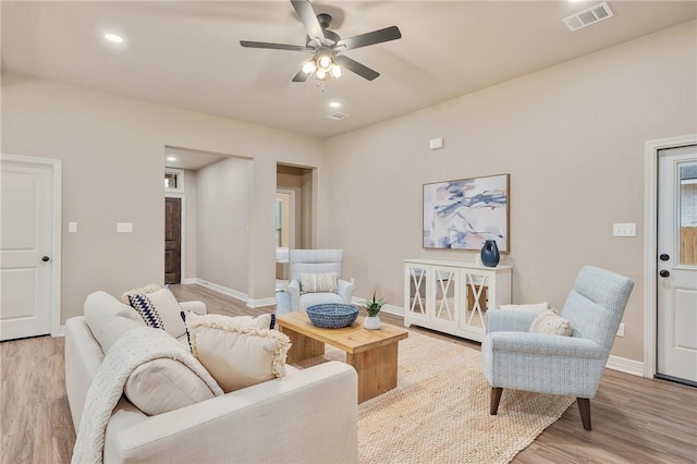 living room featuring ceiling fan and light hardwood / wood-style flooring