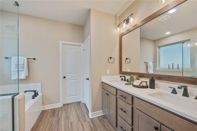 bathroom with hardwood / wood-style flooring, vanity, and a bathtub