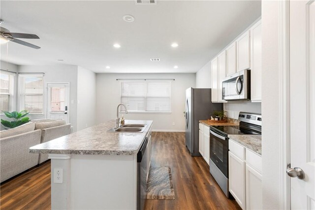 kitchen with white cabinets, sink, stainless steel appliances, and a kitchen island with sink