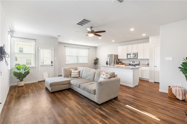 living room featuring ceiling fan, dark hardwood / wood-style flooring, and sink