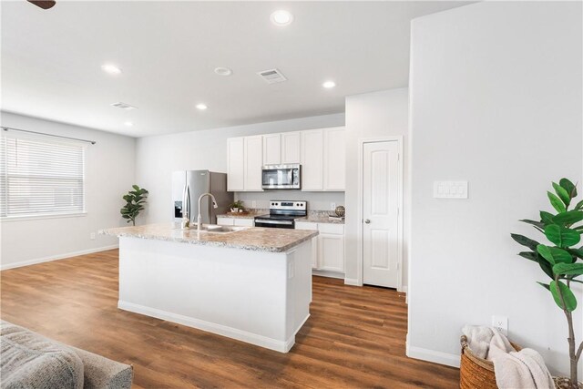 kitchen featuring stainless steel appliances, a kitchen island with sink, sink, white cabinets, and dark hardwood / wood-style floors