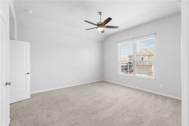 carpeted empty room featuring vaulted ceiling and ceiling fan