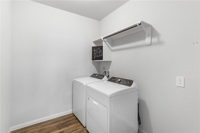 clothes washing area with washer and dryer and dark hardwood / wood-style flooring