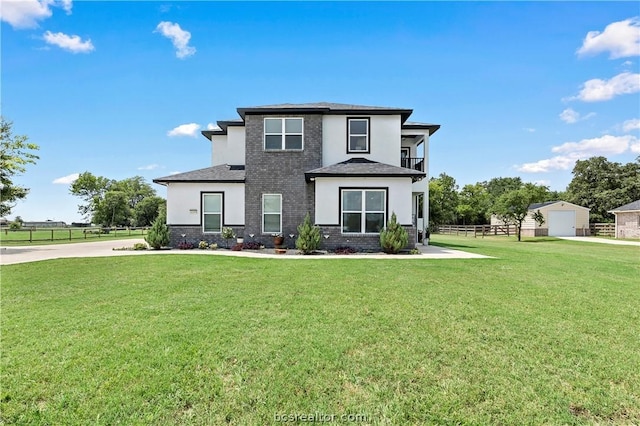 view of front of property with a balcony and a front lawn