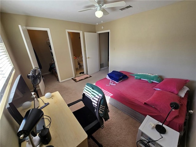 carpeted bedroom featuring ceiling fan, a spacious closet, connected bathroom, and a closet