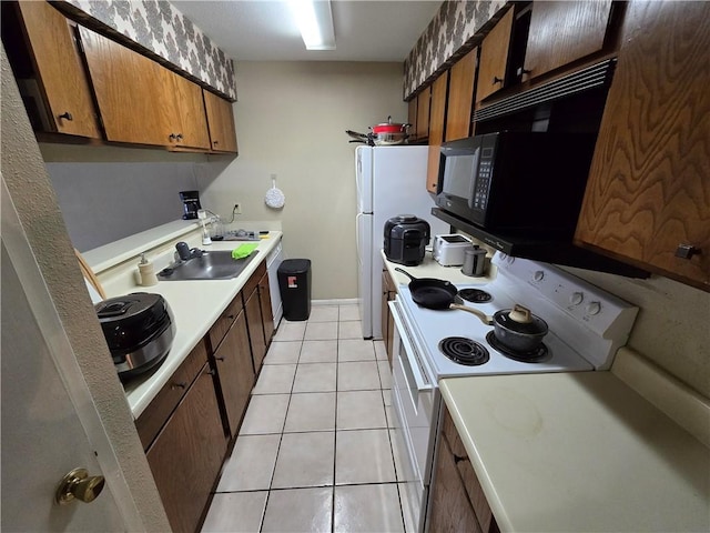 kitchen with sink, light tile patterned floors, and white appliances