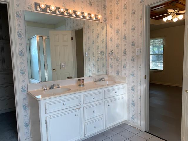 bathroom with tile patterned flooring, vanity, ceiling fan, and a shower with door