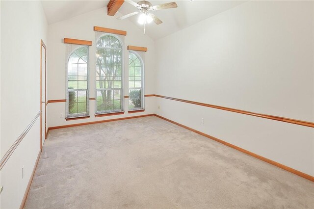 carpeted spare room featuring lofted ceiling with beams and ceiling fan