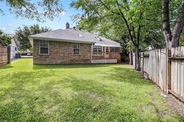 back of house with central AC unit, a yard, and a wooden deck