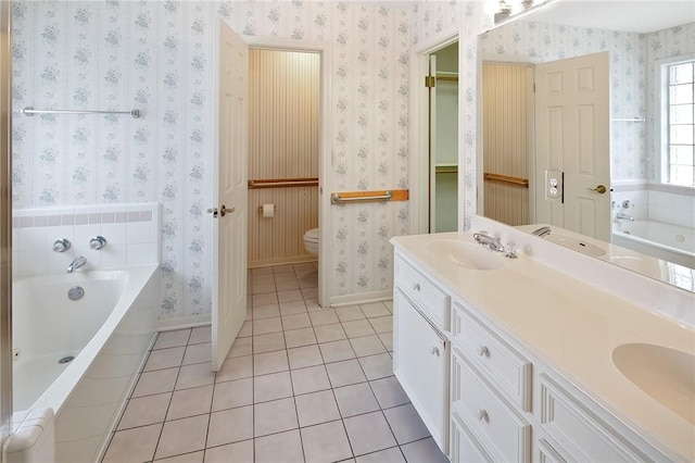 bathroom featuring tiled bath, tile patterned flooring, vanity, and toilet