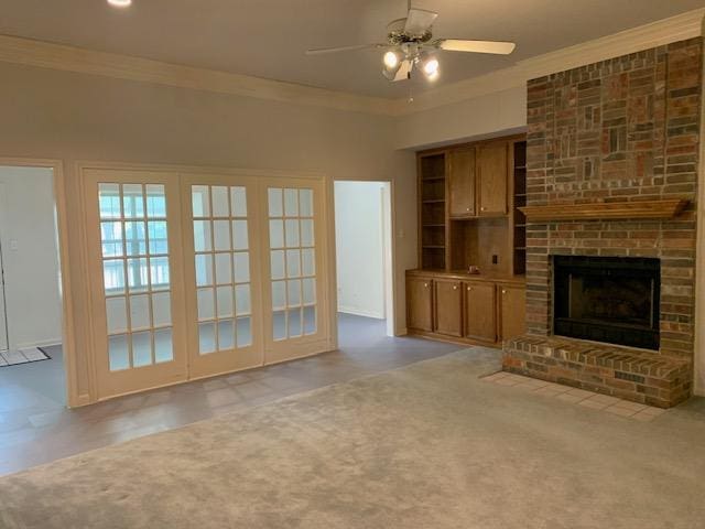 unfurnished living room featuring ceiling fan, crown molding, and a brick fireplace