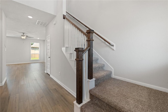 stairs with hardwood / wood-style flooring and ceiling fan