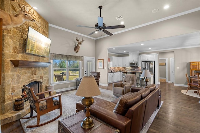 living room featuring ceiling fan, dark hardwood / wood-style flooring, ornamental molding, and a fireplace