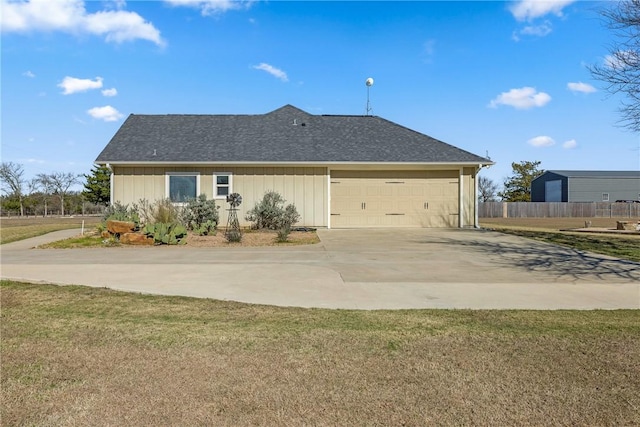 rear view of property featuring a lawn and a garage