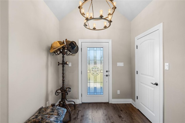 entrance foyer with dark hardwood / wood-style flooring, vaulted ceiling, and a notable chandelier