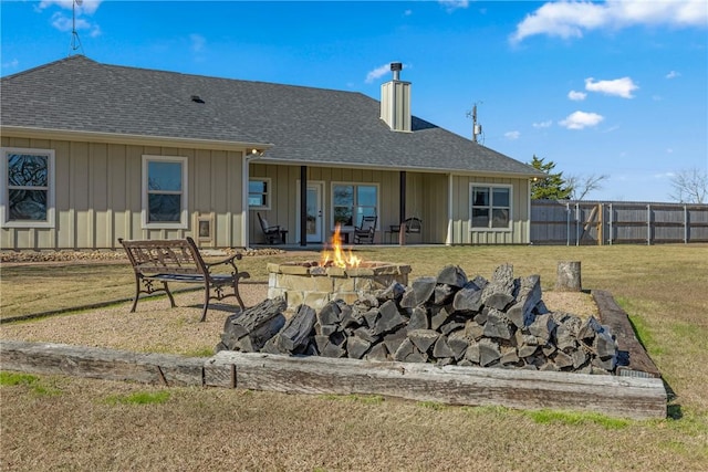 rear view of house featuring a yard and an outdoor fire pit