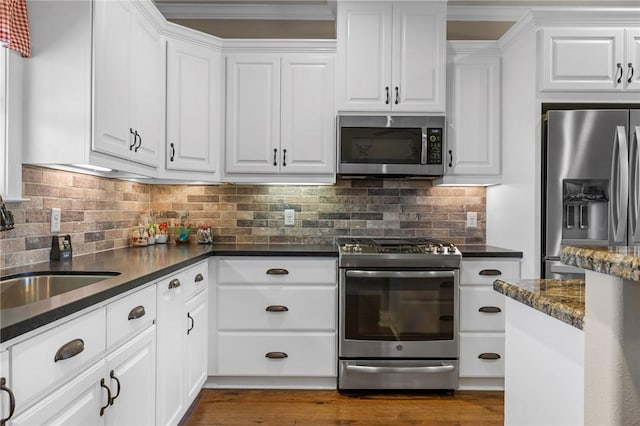 kitchen with white cabinets, backsplash, stainless steel appliances, and sink