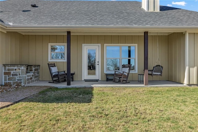 doorway to property featuring a lawn and a patio