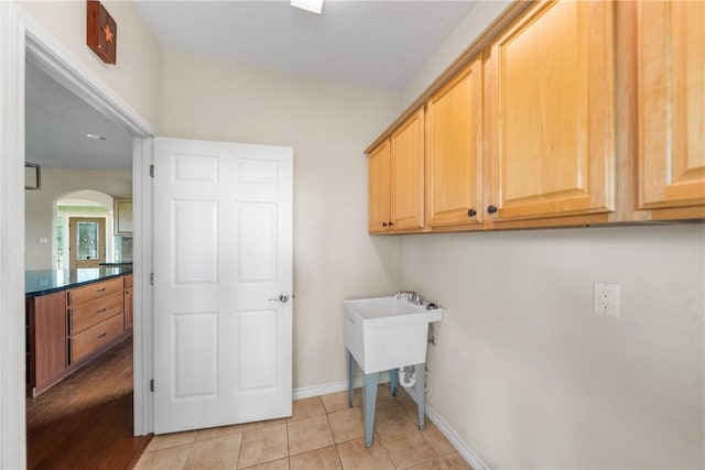 32287 Rochen Rd, Waller, TX 77484 - laundry area with cabinet space, arched walkways, and baseboards