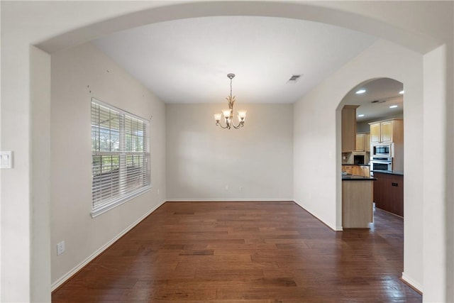 32287 Rochen Rd, Waller, TX 77484 - unfurnished dining area with dark wood-style flooring, a chandelier, baseboards, and arched walkways