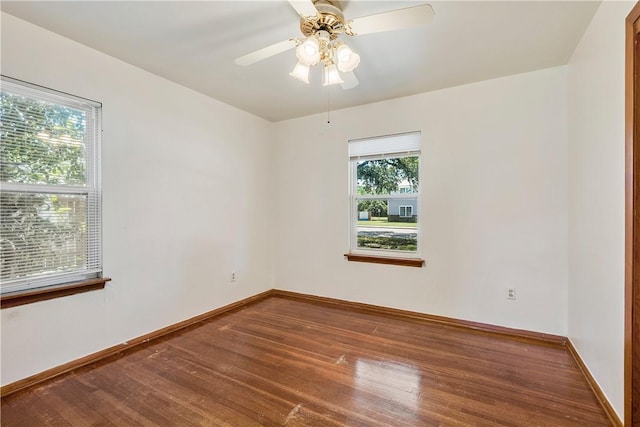 spare room with baseboards, ceiling fan, and wood finished floors