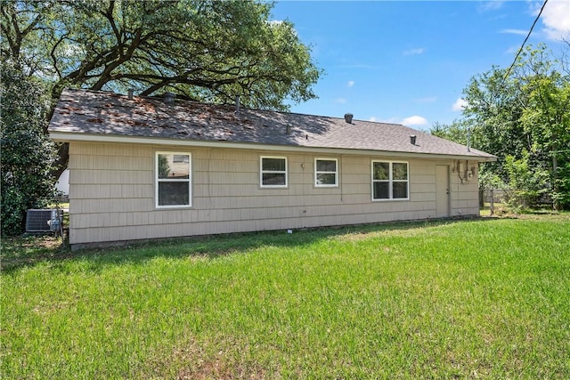rear view of house featuring a lawn and central AC