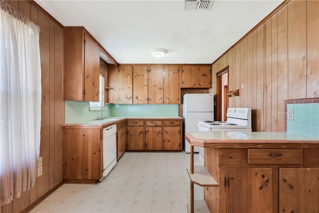 kitchen with visible vents, white appliances, light floors, tile countertops, and brown cabinets