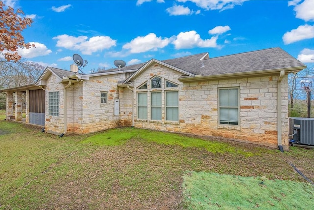 back of property featuring a lawn and central air condition unit