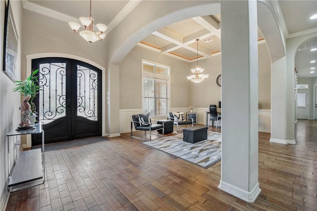 entrance foyer featuring hardwood / wood-style flooring, coffered ceiling, and a chandelier