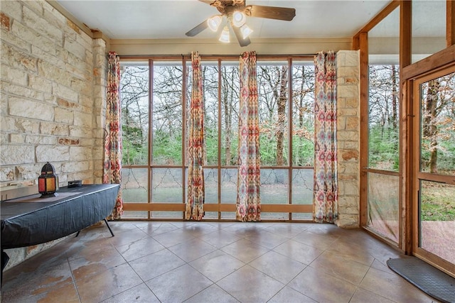 unfurnished sunroom with ceiling fan and a healthy amount of sunlight