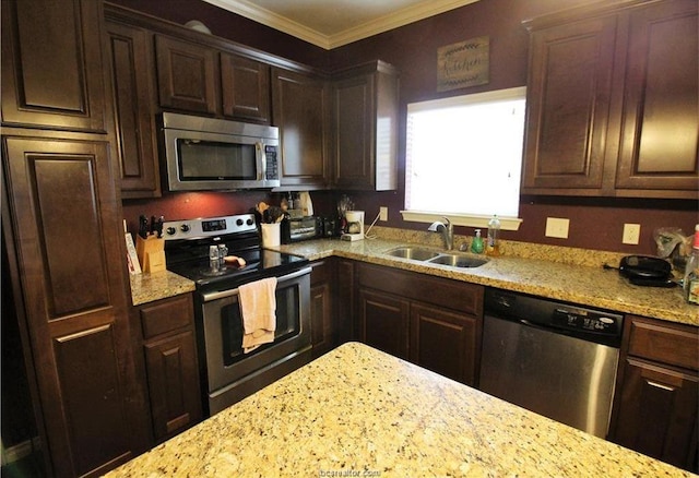 kitchen with stainless steel appliances, crown molding, a sink, and light stone counters