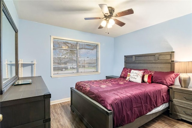 bedroom featuring baseboards, wood finished floors, and a ceiling fan