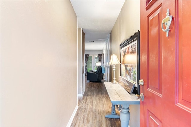 hallway with baseboards and wood finished floors