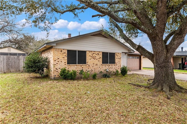 ranch-style home with brick siding, fence, a front yard, a garage, and driveway