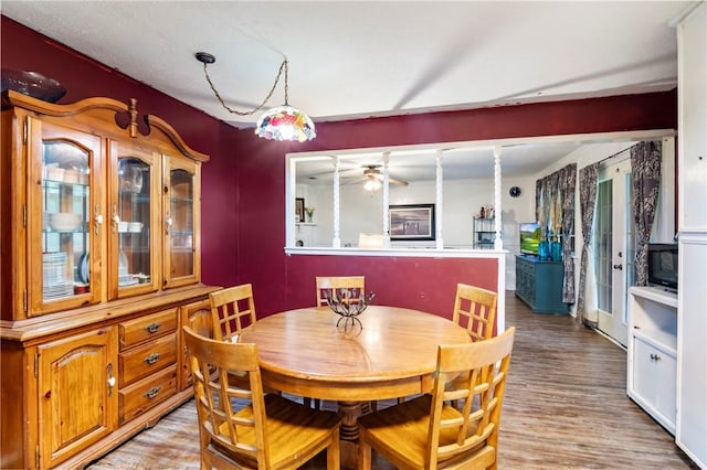 dining area with light wood finished floors and a ceiling fan