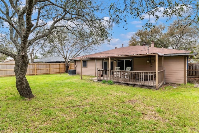 rear view of property with a lawn, central AC, and a fenced backyard