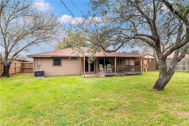 back of house with central AC unit, a yard, and a fenced backyard