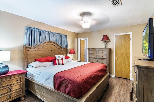 bedroom featuring wood finished floors, visible vents, and baseboards