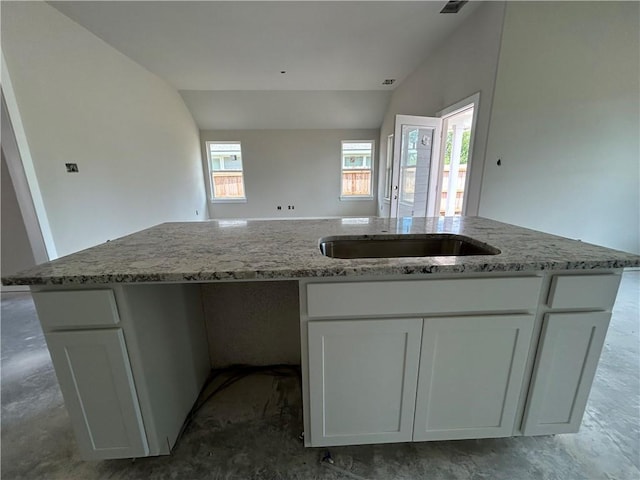2814 Messenger Way, Bryan, TX 77802 - kitchen featuring plenty of natural light, white cabinets, light stone counters, lofted ceiling, and a kitchen island with sink