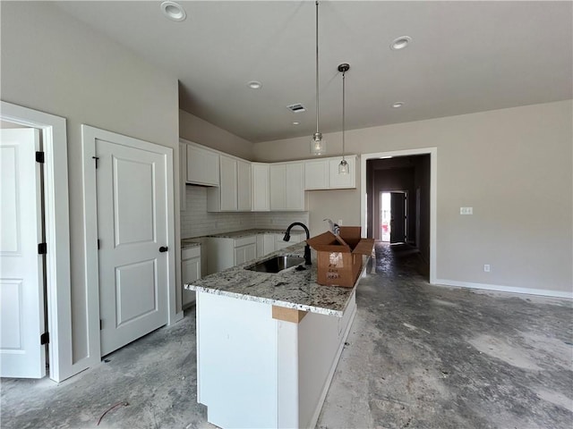 2814 Messenger Way, Bryan, TX 77802 - kitchen featuring concrete floors, white cabinetry, a kitchen island with sink, light stone counters, and backsplash
