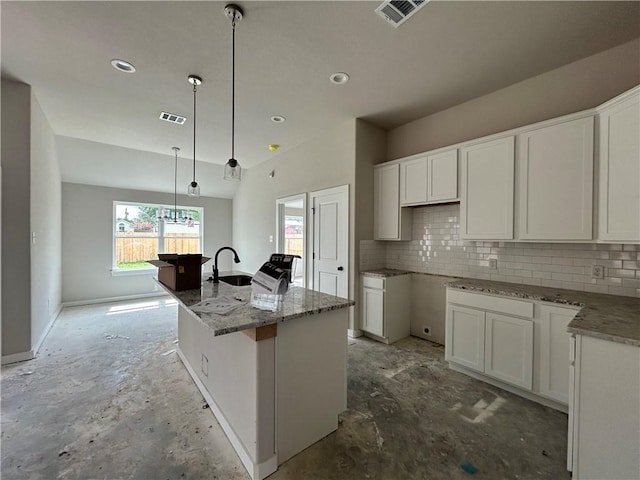 2814 Messenger Way, Bryan, TX 77802 - kitchen featuring backsplash, an island with sink, white cabinetry, light stone countertops, and hanging light fixtures