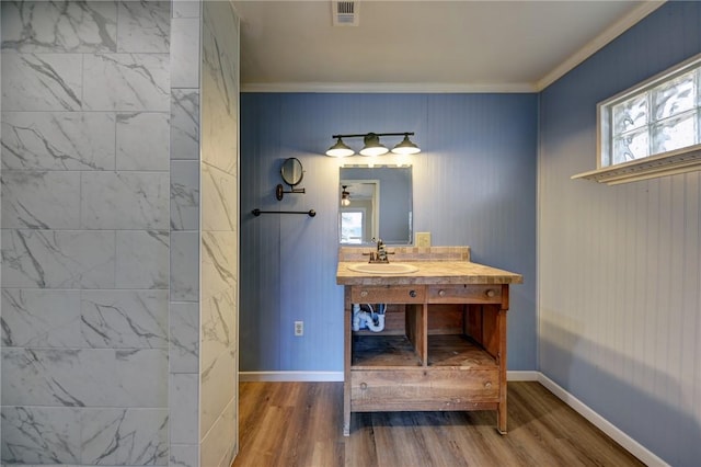 bathroom with ornamental molding, vanity, and wood-type flooring