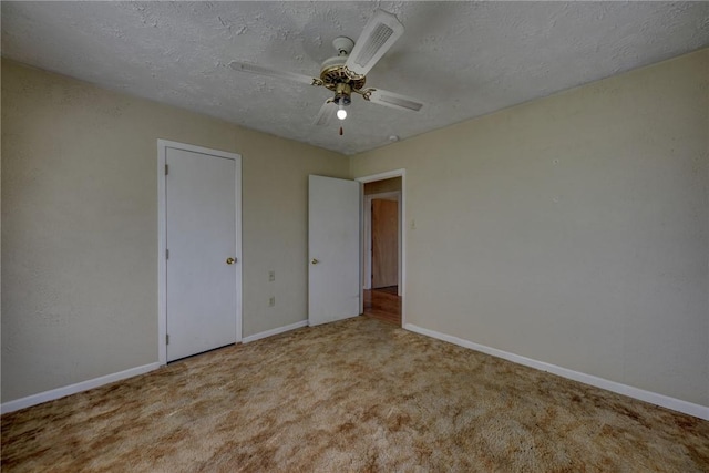 unfurnished bedroom with ceiling fan, light colored carpet, and a textured ceiling