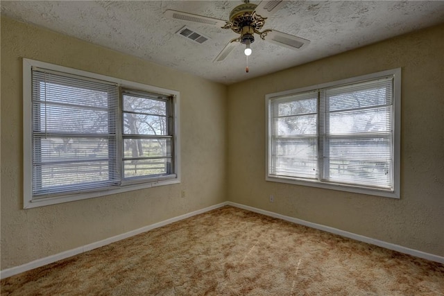 carpeted spare room with a textured ceiling and ceiling fan