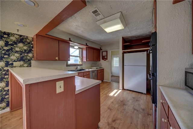 kitchen featuring kitchen peninsula, stainless steel dishwasher, light hardwood / wood-style flooring, white refrigerator, and sink